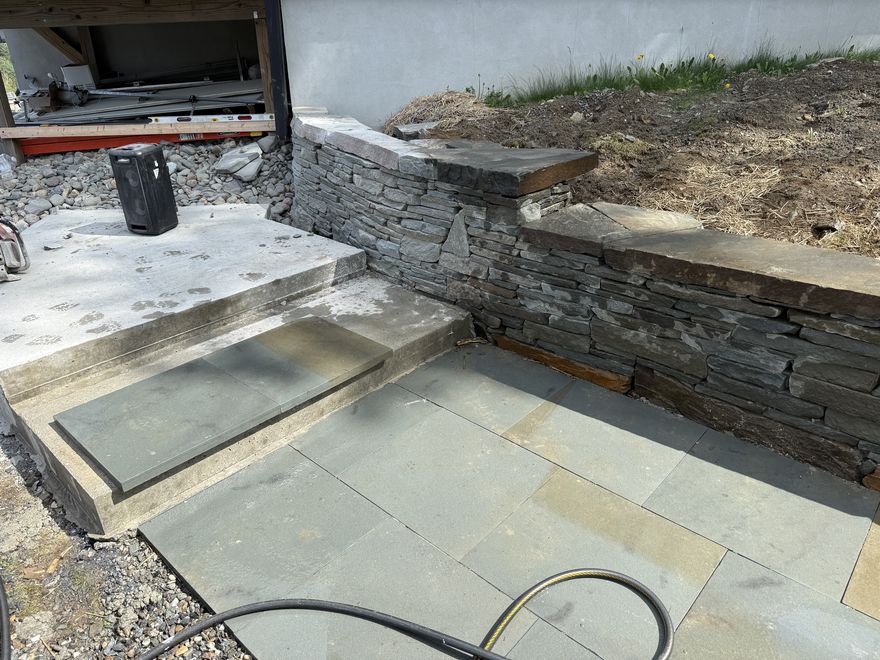 Dry-stacked stone wall with bluestone patio and stone steps