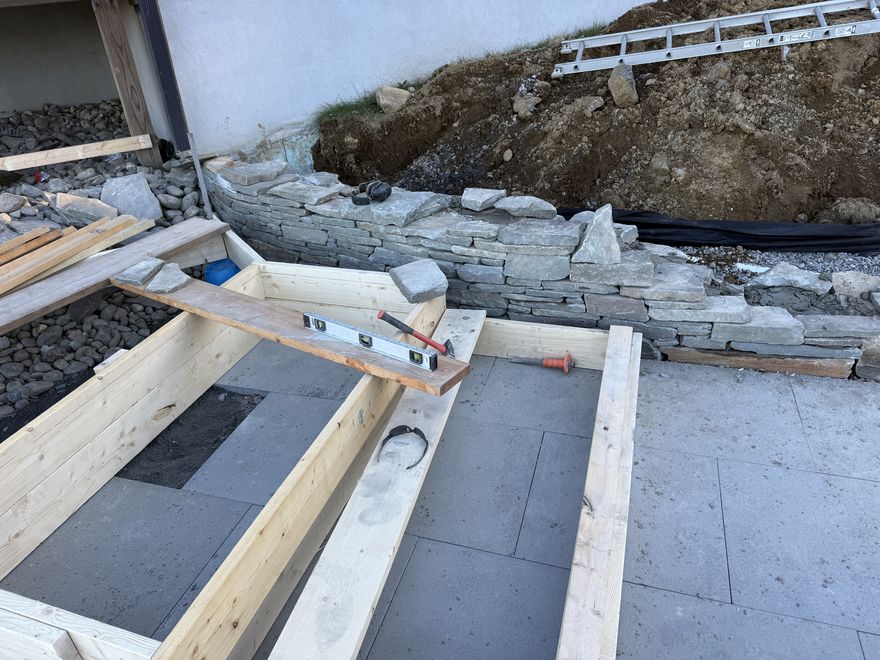 Natural stone wall alongside a stone walkway