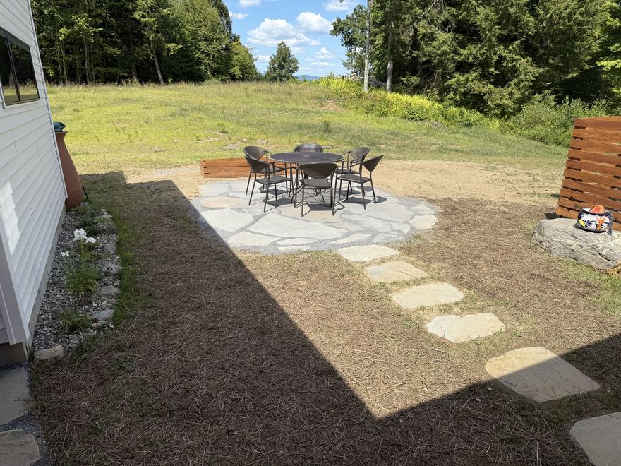 Stone patio with dining set and mountain view